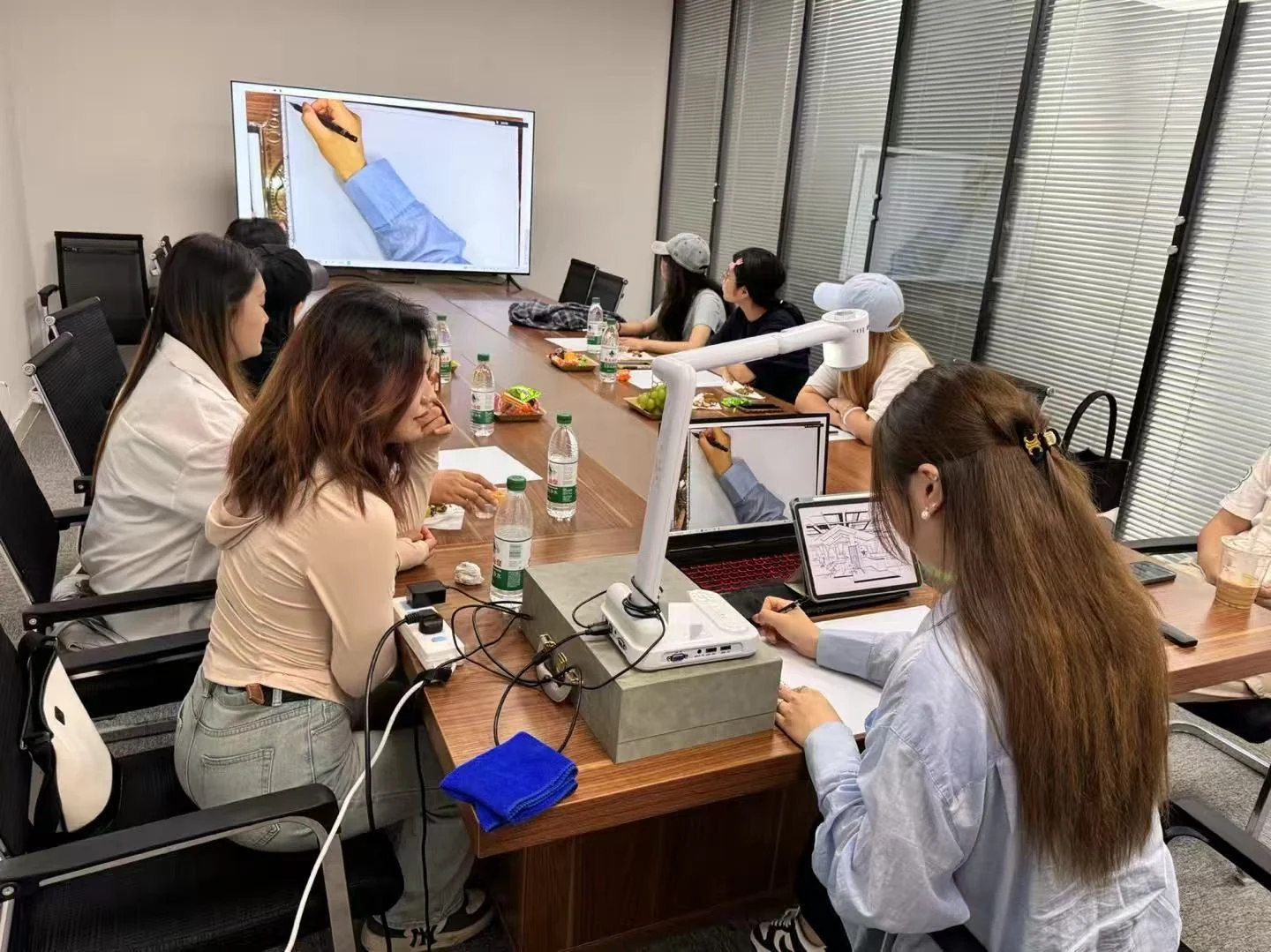 无界设计教育小组课堂，学员在屏幕演示旁练习绘画与设计表达
