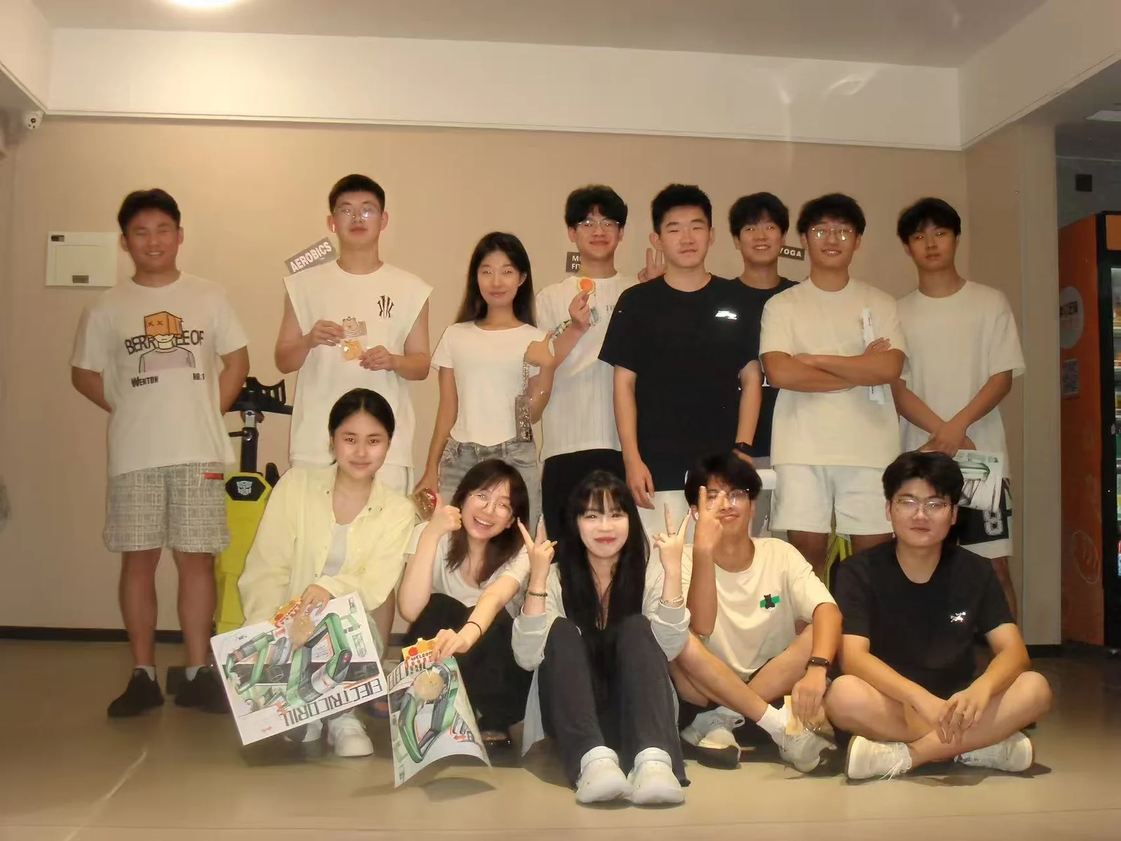 无界设计教育师生在室内合影，前排展示手中的设计图稿